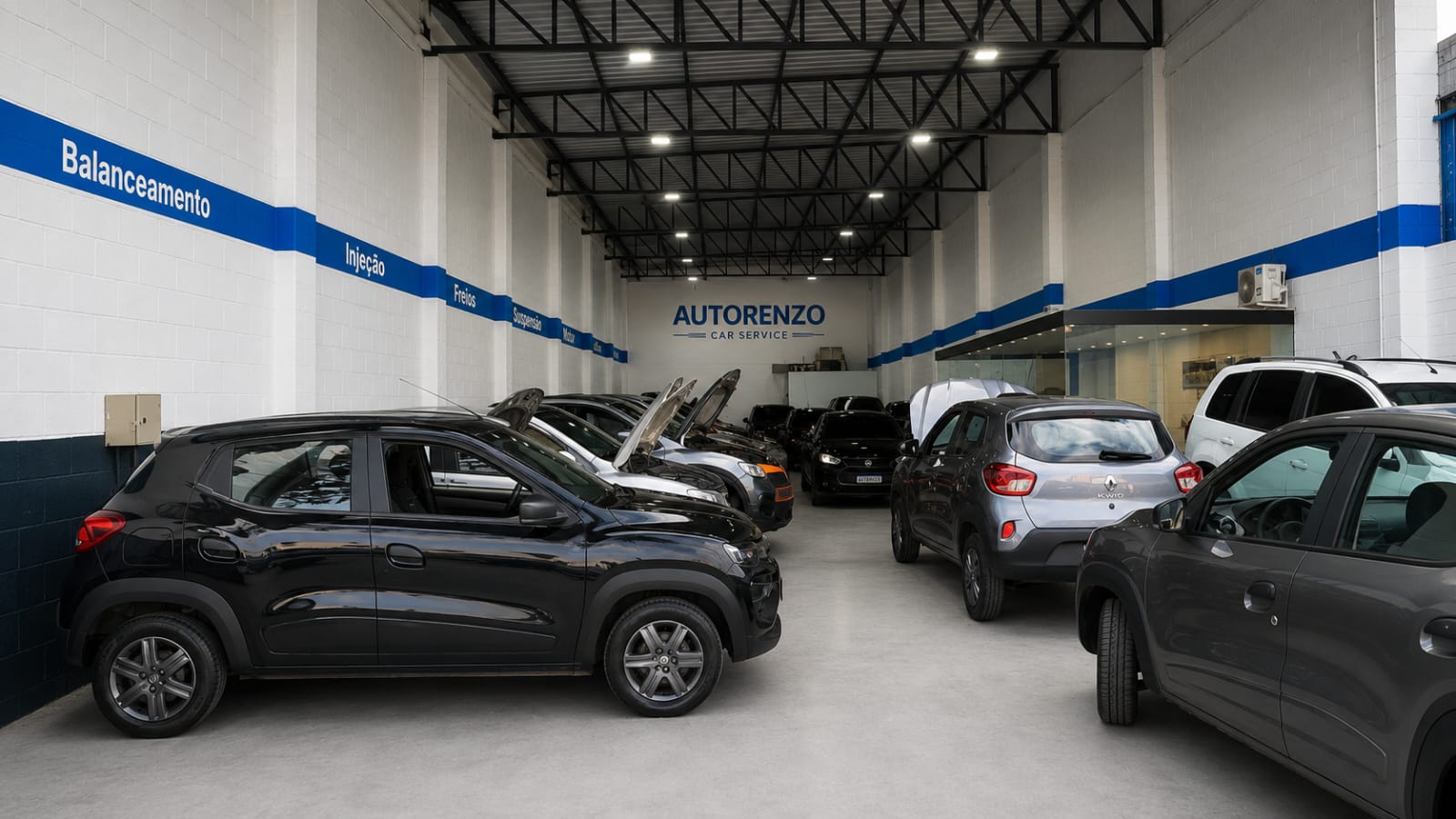 Área interna da oficina Autorenzo com veículos em diferentes etapas de serviço